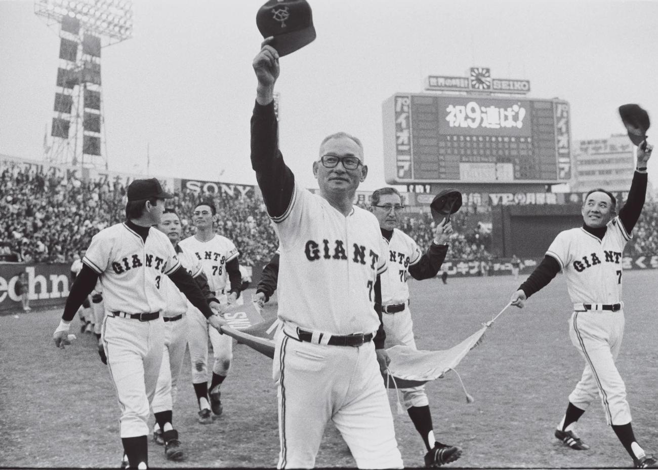 73年11月、日本シリーズ9連覇を達成した川上哲治監督（中央）ら巨人ナインは、「祝9連覇」と表示されたのスコアボードをバックにペナントを持って場内一周