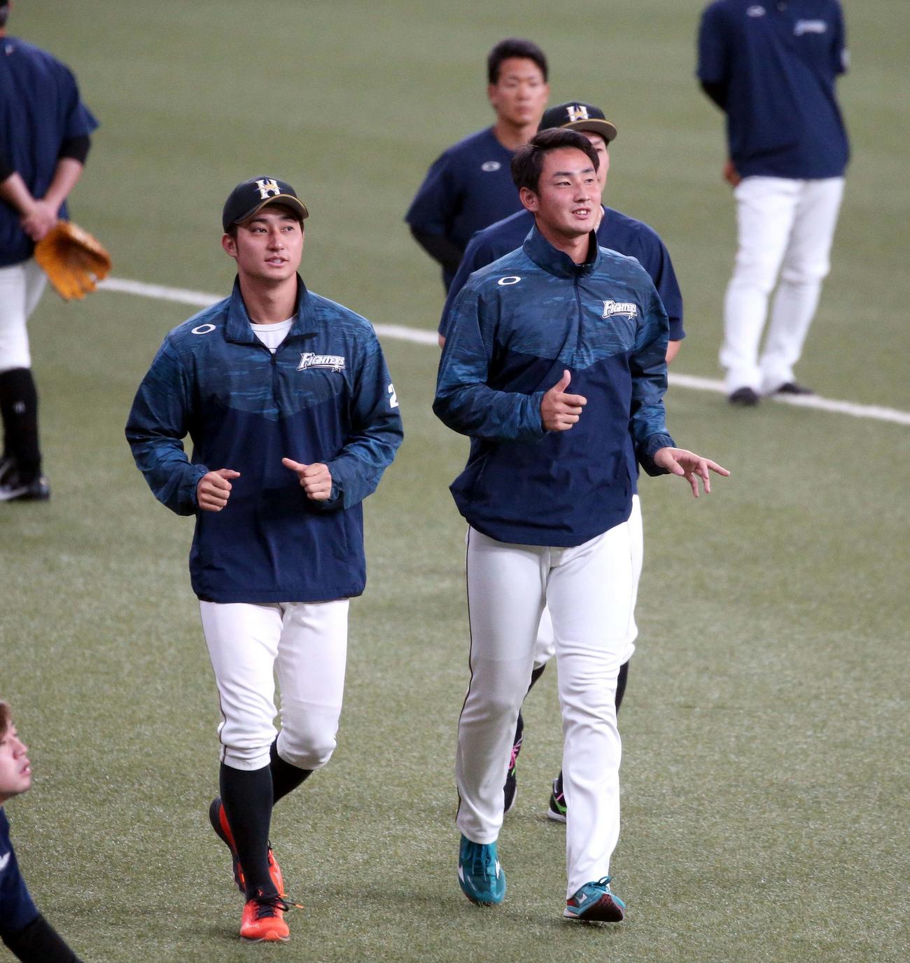 オリックス対日本ハム　顔が似ていると言われる浅間（左）とランニングする望月（撮影・黒川智章）