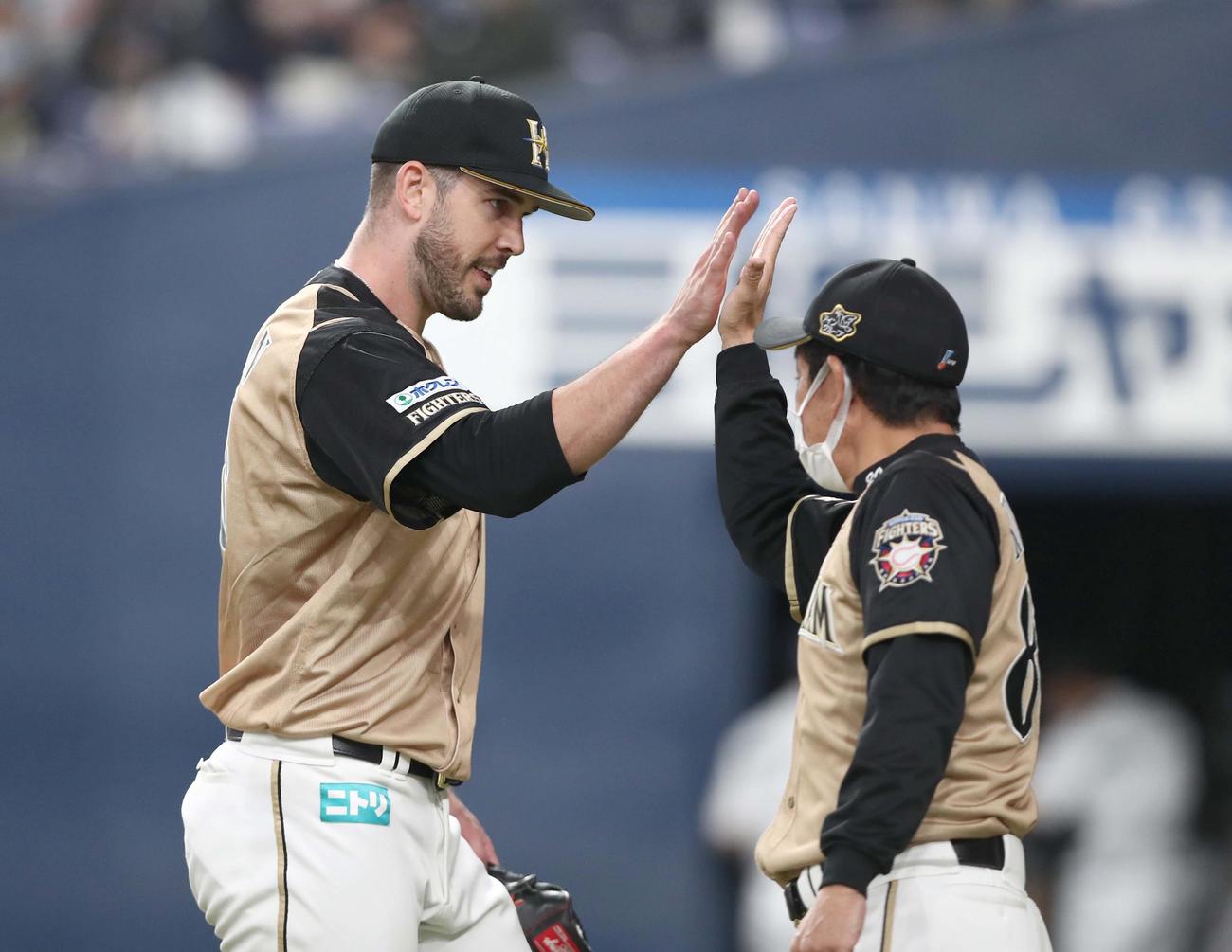 オリックス対日本ハム　試合後、栗山監督（右）に出迎えられるバーヘイゲン（撮影・黒川智章）