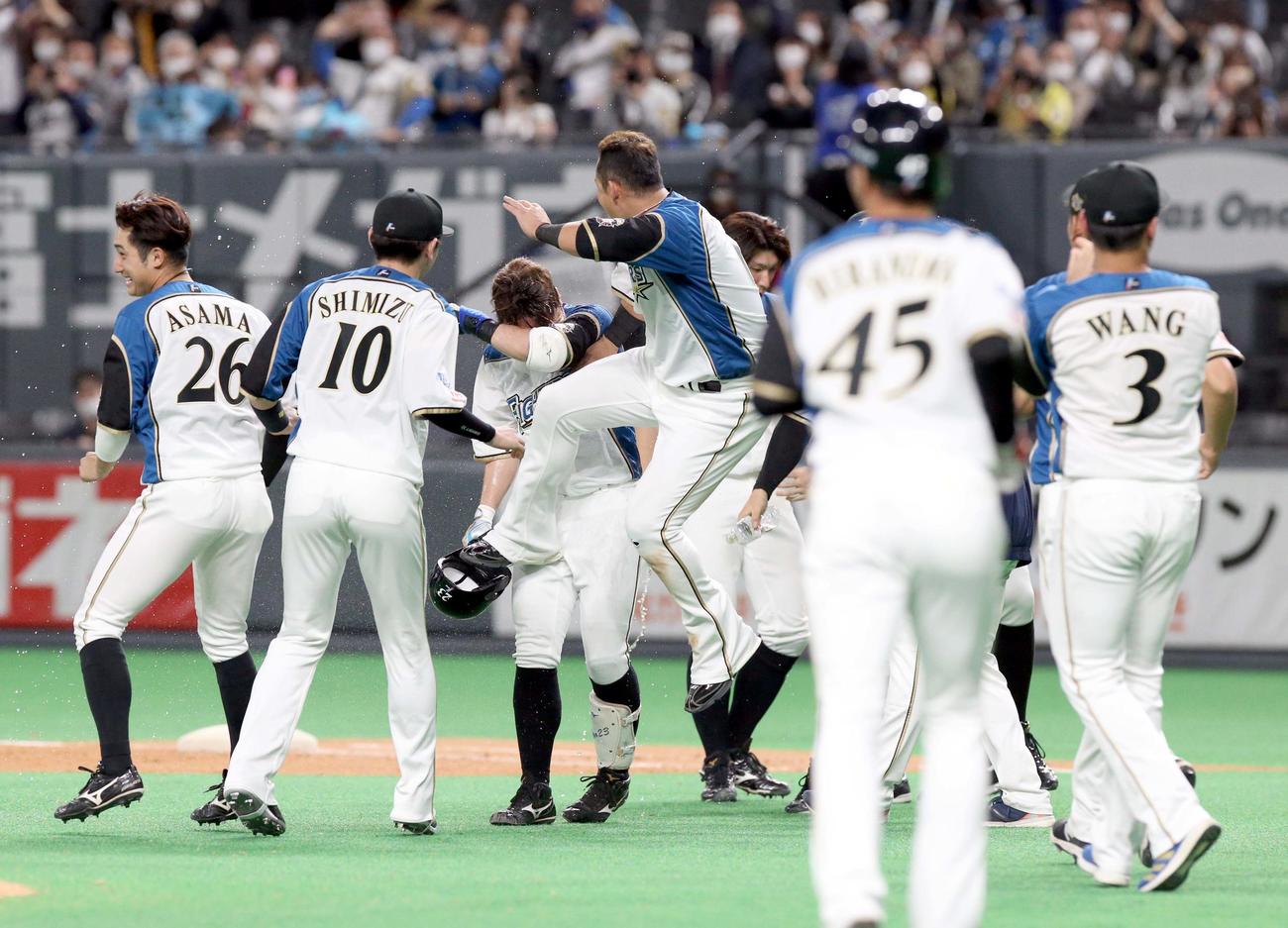 日本ハム対オリックス　10回裏日本ハム1死満塁、渡辺（中央奥）はサヨナラ右犠飛を放ち中田に手荒い祝福をされる（撮影・佐藤翔太）