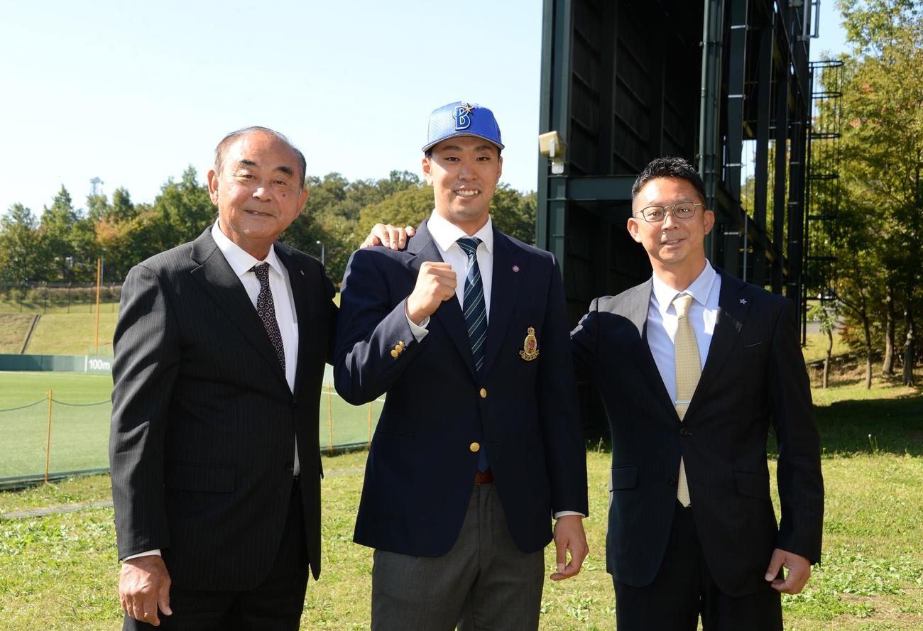 DeNAドラフト1位の明大・入江（中央）は吉田顧問（左）と担当の八馬スカウトから指名あいさつを受け、笑顔で健闘を誓う（撮影・鈴木正章）