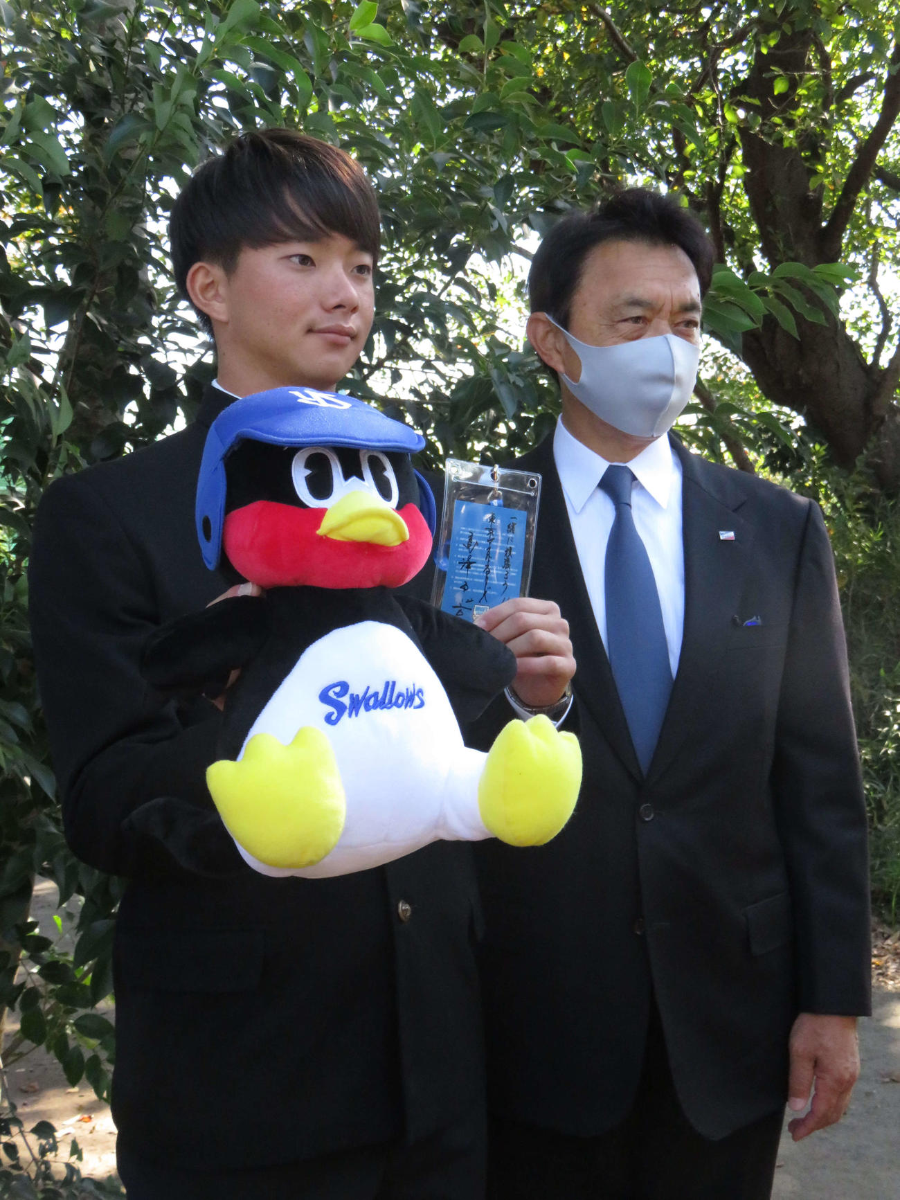 ヤクルト小川GM（右）から指名あいさつを受けたドラフト1位の慶大・木沢。左手には高津監督からの「一緒に頑張ろう！！」のメッセージ