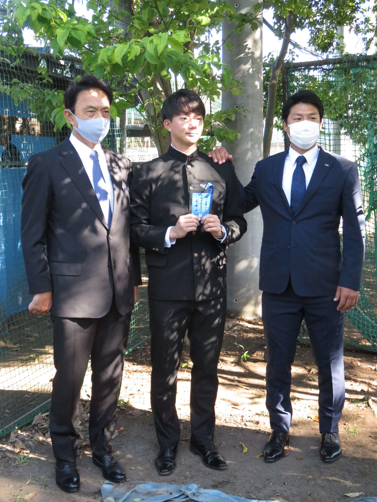 ヤクルトのドラフト1位、慶大・木沢尚文投手（22＝中央）が指名あいさつを受けた。左が小川GM、右は山本担当スカウト