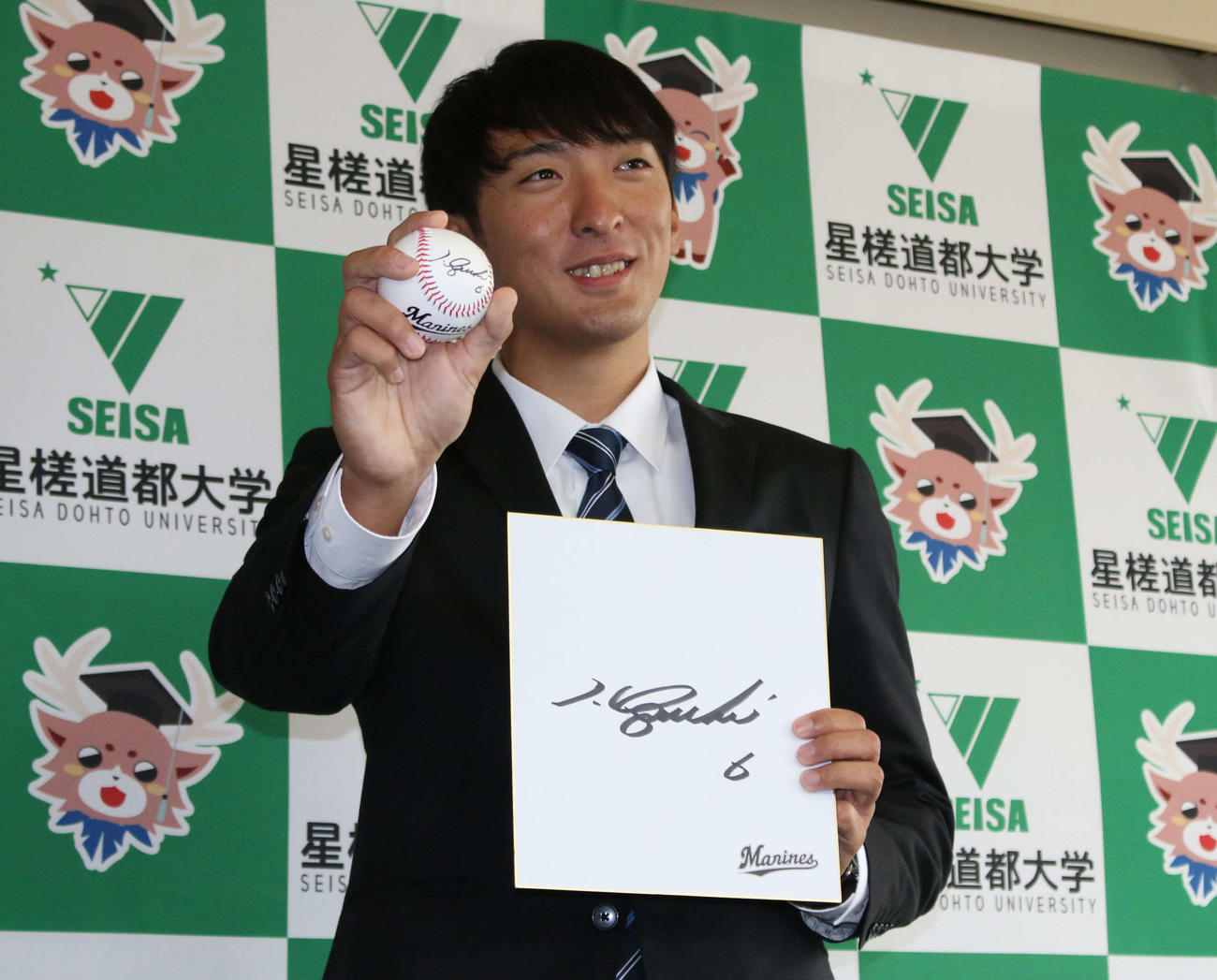 ロッテからドラフト4位指名された星槎道都大・河村は、井口監督の直筆のサイン色紙とサインボールをプレゼントされて笑顔を見せる（撮影・木下大輔）