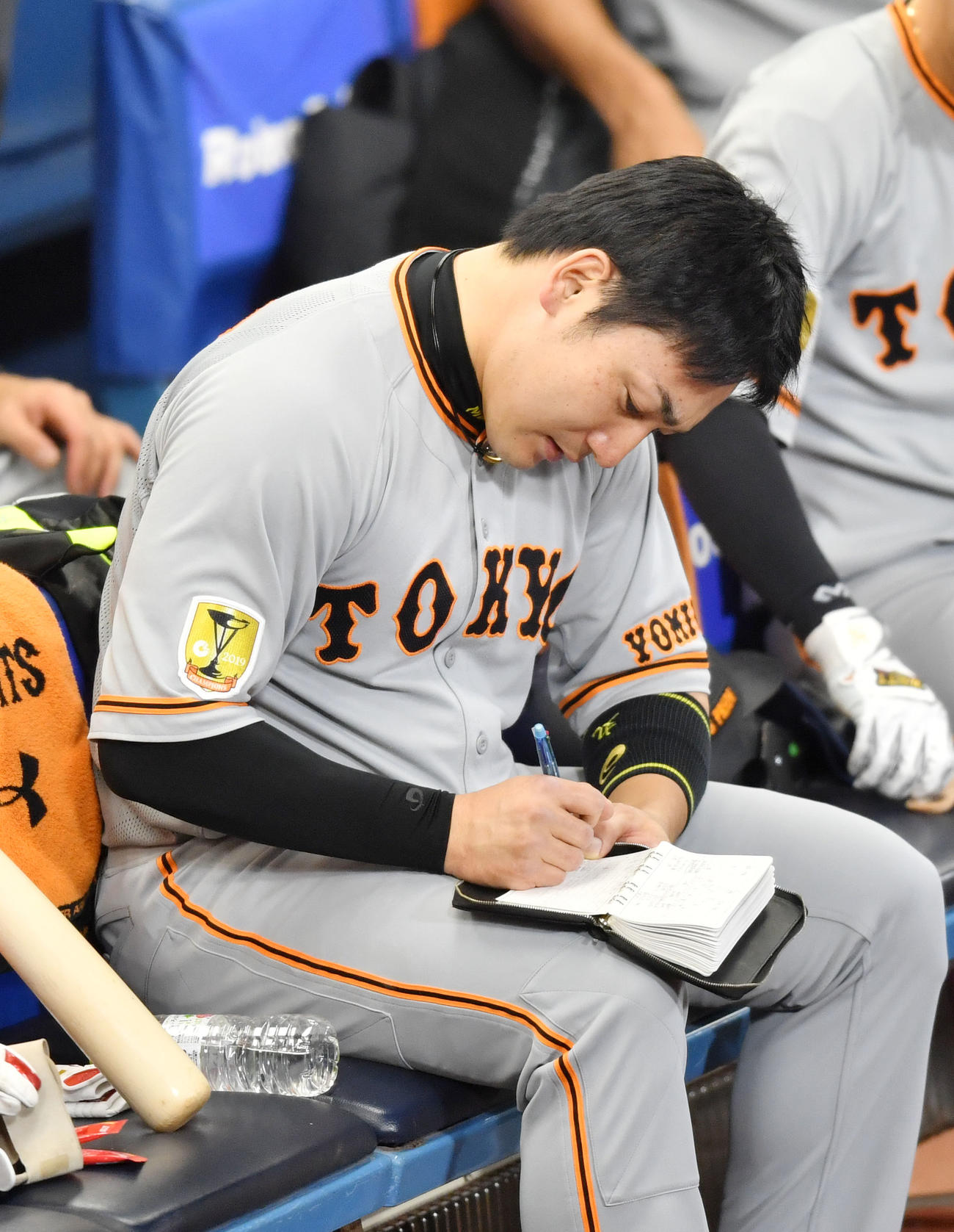 DeNA対巨人　2回表巨人1死、通算200号となる右越え本塁打を放った丸はベンチに戻ってすぐメモを取る（撮影・横山健太）