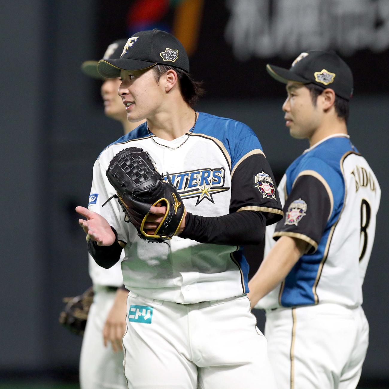 日本ハム対オリックス　5回表を無失点を抑えグラブをたたきながらベンチに戻る日本ハム吉田輝（撮影・佐藤翔太）