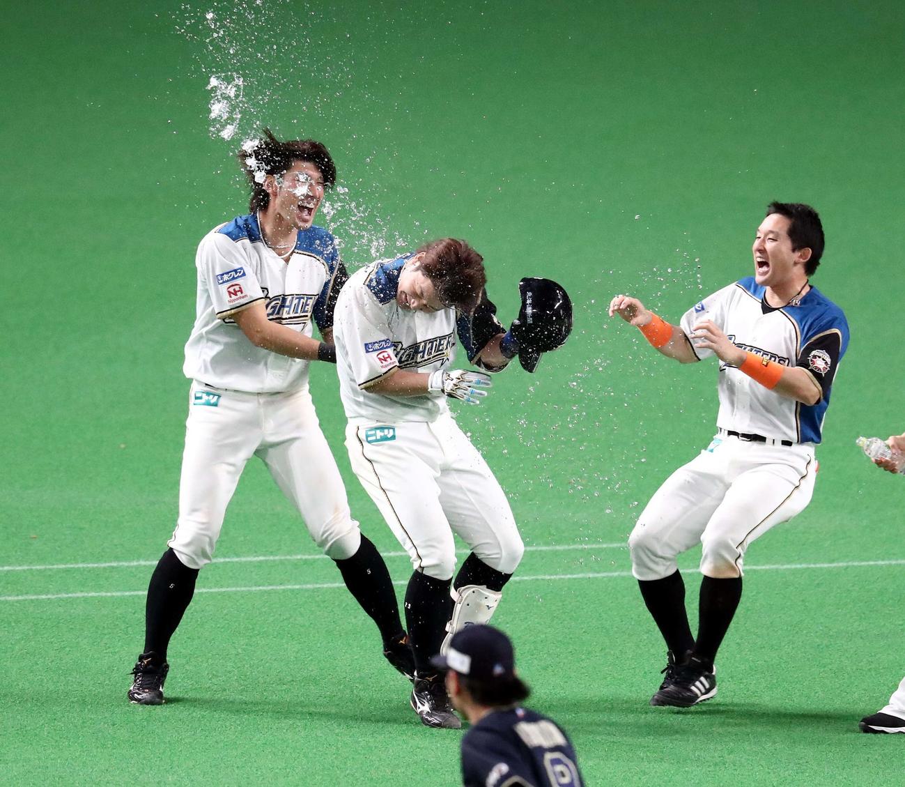 日本ハム対オリックス　10回裏、サヨナラ右犠飛を放った渡辺は大田らに水をかけられる（撮影・黒川智章）