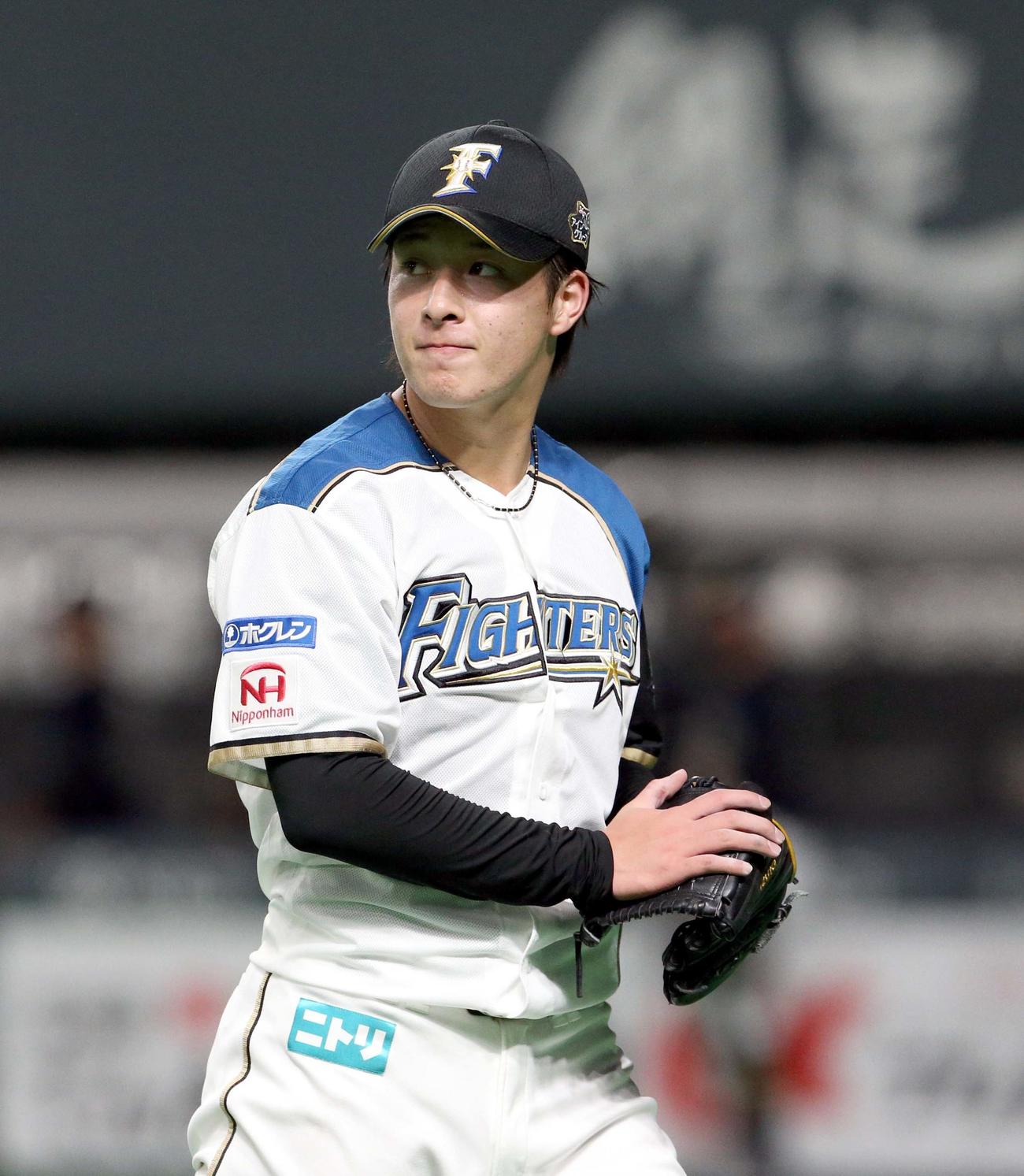 日本ハム対オリックス　4回表を無失点を抑えグラブをたたきながらベンチに戻る日本ハム吉田輝（撮影・佐藤翔太）