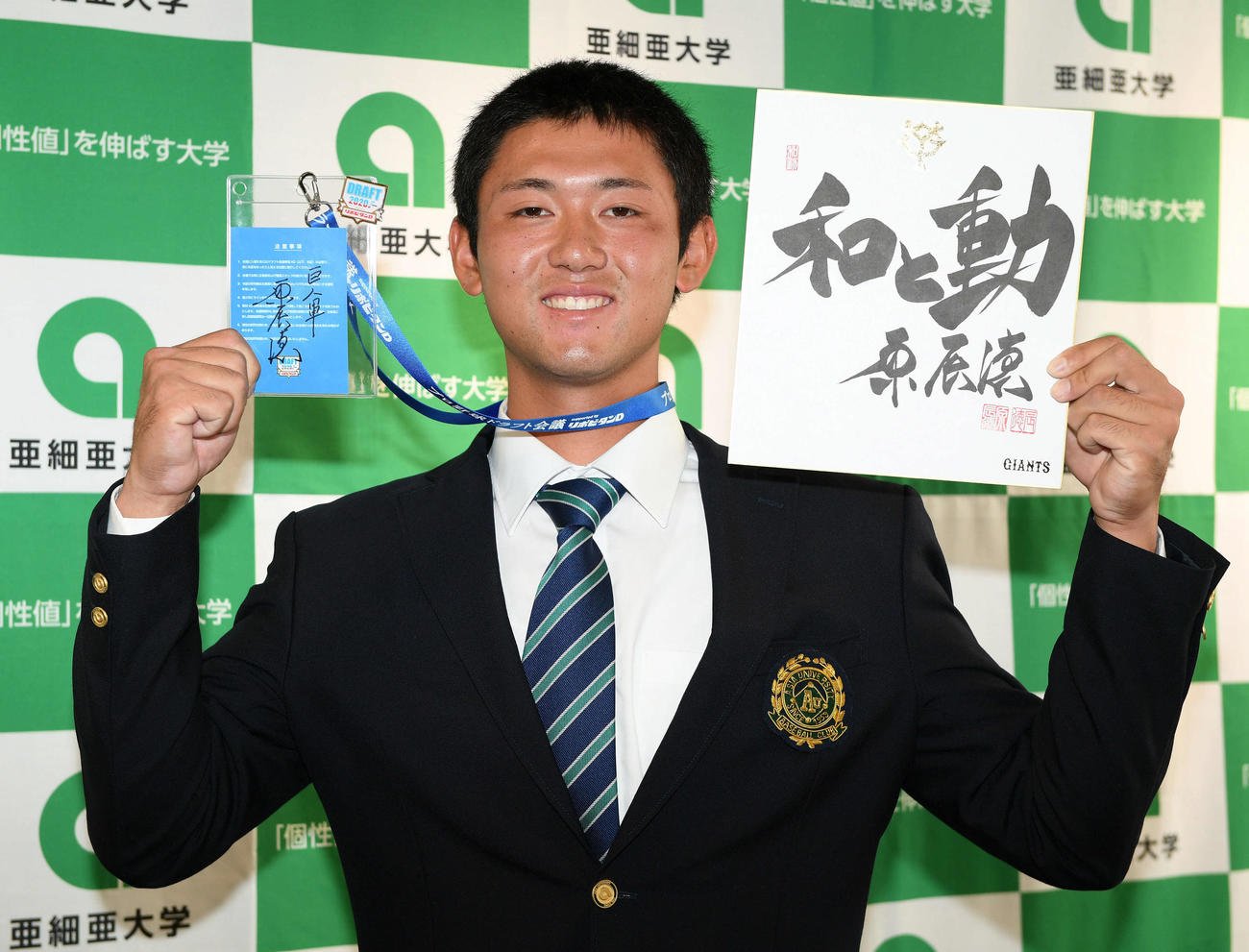 指名あいさつを受けた巨人ドラフト1位の亜大・平内は原監督の直筆の色紙とサイン入りのドラフト会議のパスを手に笑顔を見せる（撮影・滝沢徹郎）