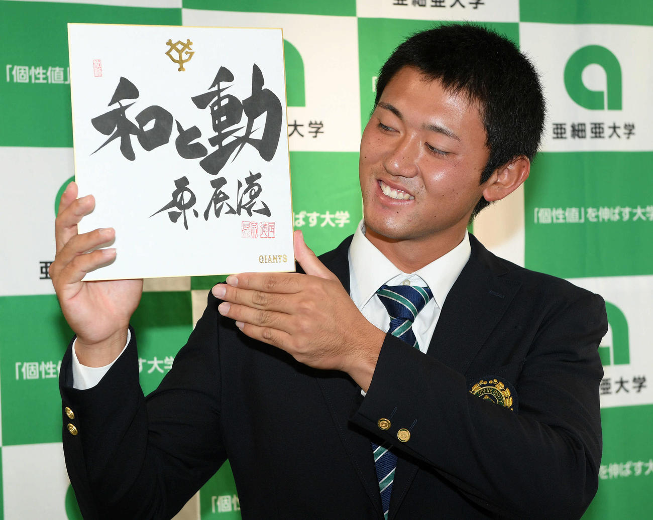 指名あいさつを受けた巨人ドラフト1位の亜大・平内は原監督の直筆の色紙を笑顔で見つめる（撮影・滝沢徹郎）