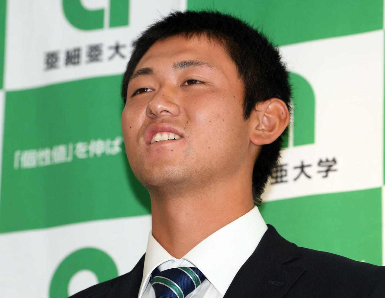 巨人から指名あいさつを受けたドラフト1位の亜大・平内は笑顔で報道陣の取材に応じる（撮影・滝沢徹郎）