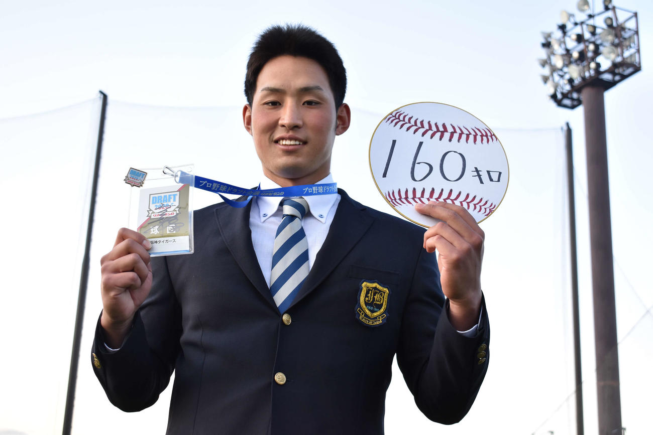 阪神ドラフト3位の上武大・佐藤は目標の球速「160キロ」と書かれた色紙とドラフト会議で使用された矢野監督サイン入りの入館パスを持って笑顔を見せる（撮影・只松憲）