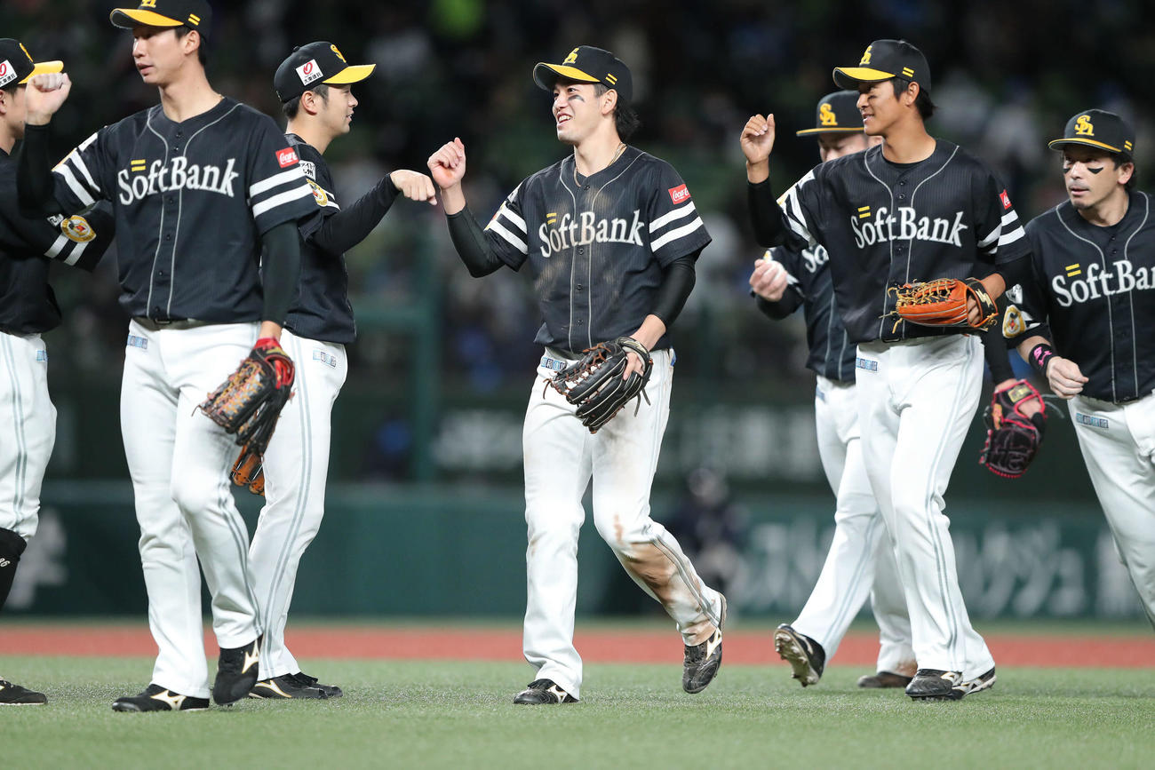 西武対ソフトバンク　西武に勝利し、ナインとグータッチをしながらベンチに引き揚げる栗原（中央）（撮影・河田真司）