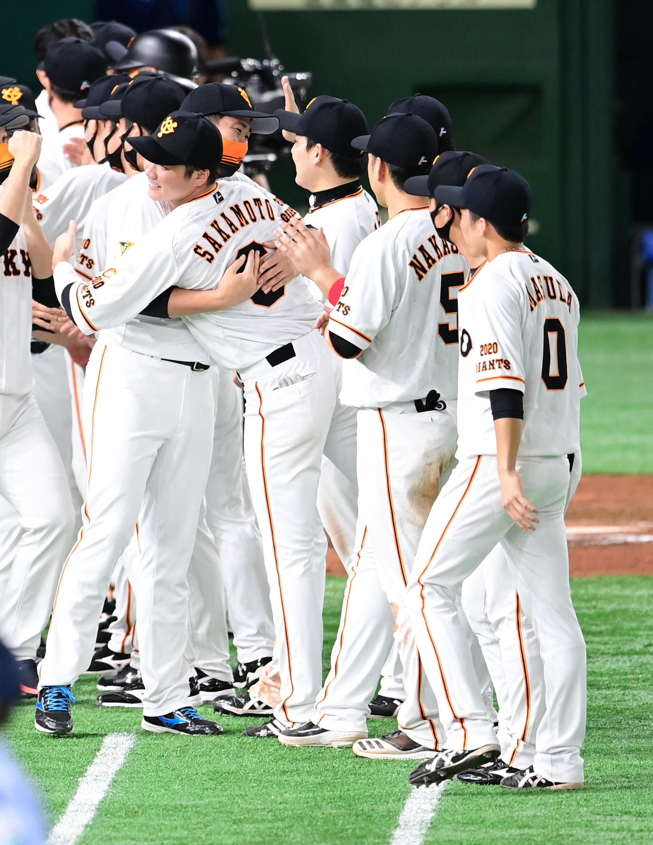 巨人対ヤクルト　2連覇を果たし優勝セレモニーで坂本（中央）と熱い抱擁を交わす菅野（同左）（撮影・小沢裕）