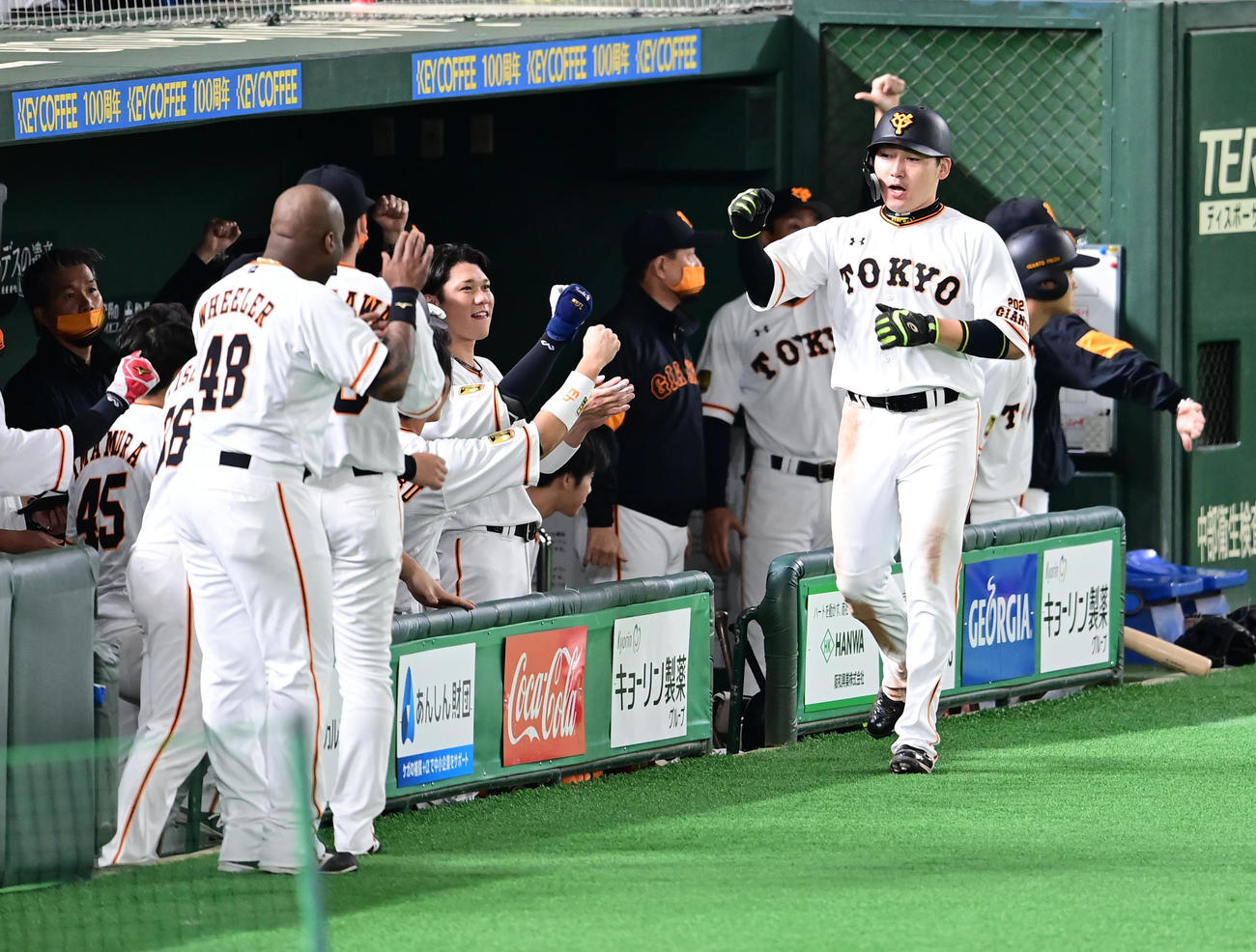 巨人対ヤクルト　6回裏巨人1死三塁、大城の左前勝ち越し適時打で生還した丸（右）はベンチのナインの祝福を受ける（撮影・小沢裕）