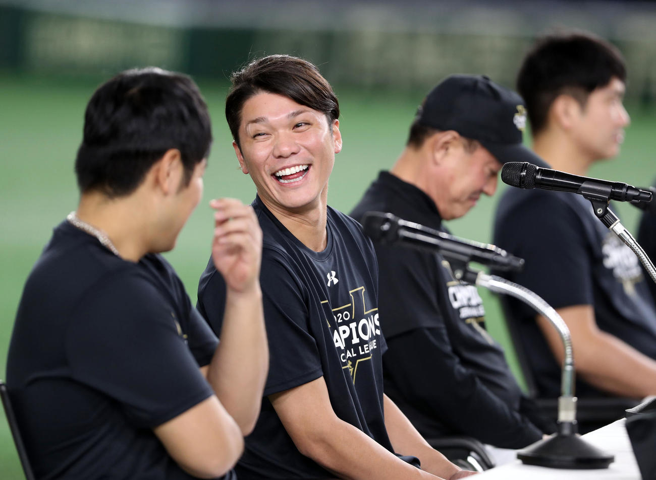 優勝会見で、岡本（手前）に笑顔を見せる坂本（撮影・狩俣裕三）