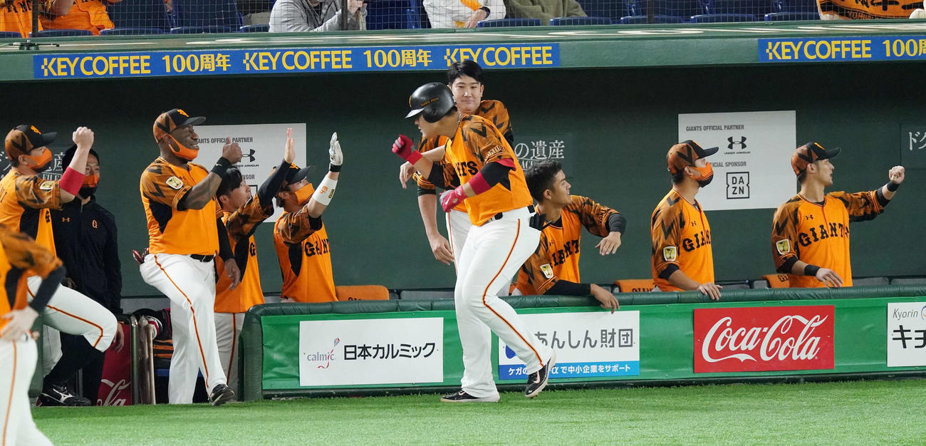 巨人対ヤクルト　5回裏巨人1死一、三塁、左越え3点本塁打を放った岡本（中央手前）の頭をたたく菅野（中央奥）（撮影・鈴木みどり）