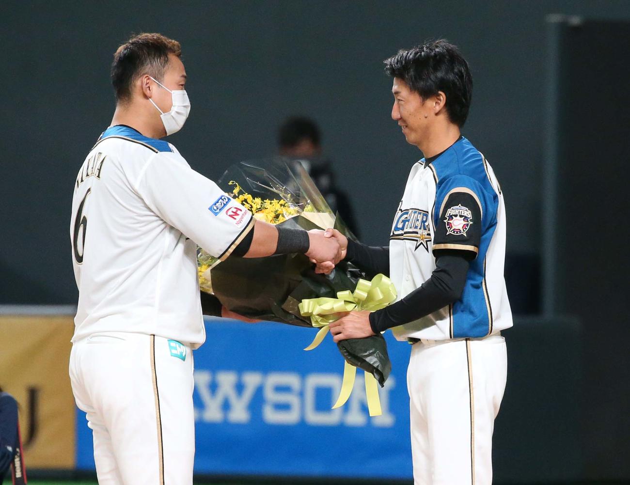 日本ハム対オリックス　引退セレモニーで中田（左）から花束を受け取る浦野（撮影・黒川智章）