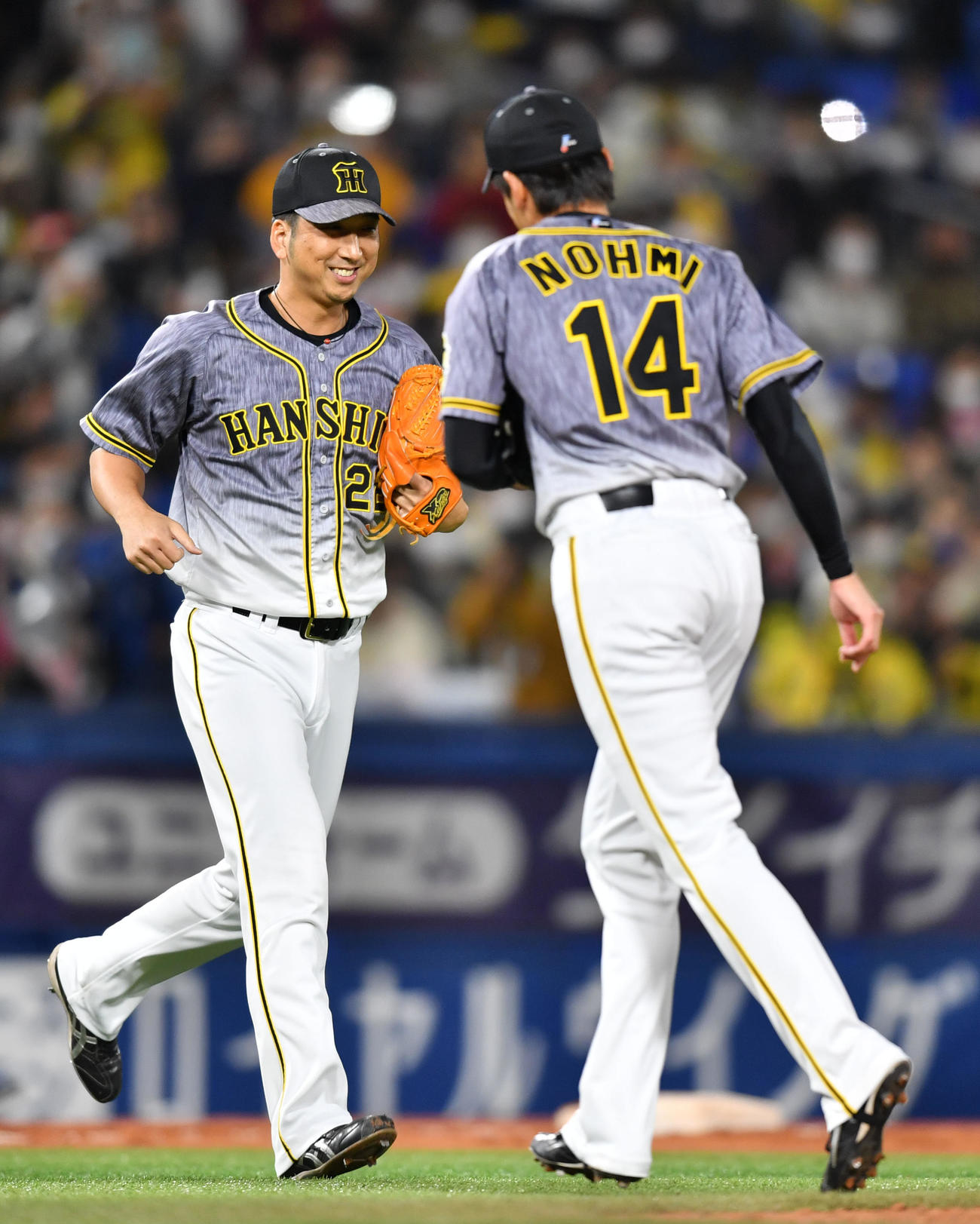 DeNA対阪神　9回裏DeNA2死二塁、笑顔でマウンドへ向かう阪神藤川（左）。右は能見（撮影・横山健太）