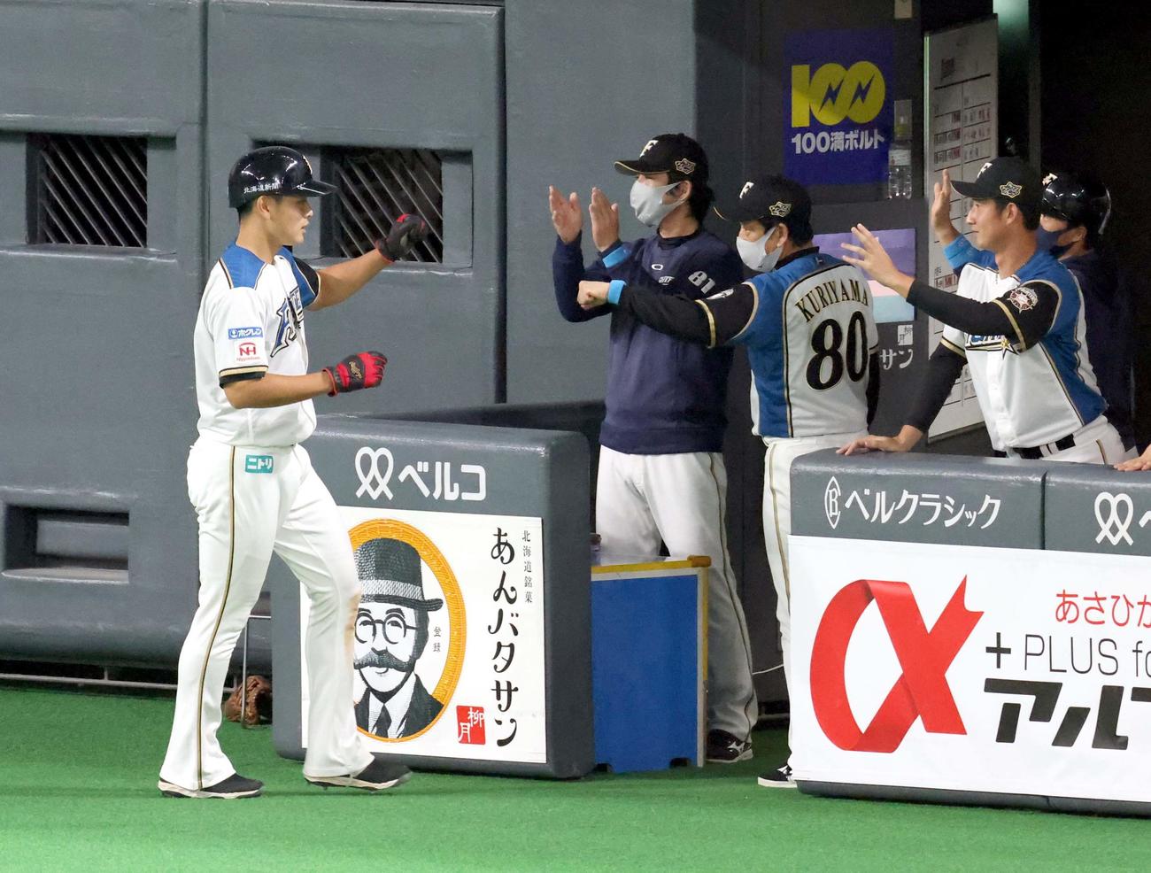 日本ハム対オリックス　3回裏日本ハム2死三塁、宇佐見の中前適時打で生還した野村（左）は栗山監督に出迎えられる（撮影・佐藤翔太）