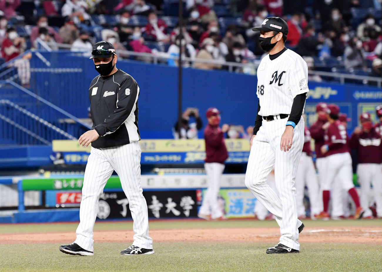 ロッテ対楽天　引き分けに終わりファンにあいさつし引き揚げるロッテ井口監督（左）と鳥越ヘッドコーチ