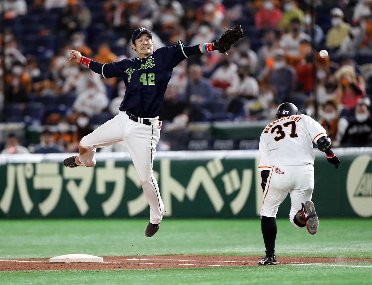 巨人対ヤクルト　5回裏巨人2死二塁、ジャンプするも三塁手村上の悪送球を捕れずに失点を許す坂口（左）。右は若林（撮影・狩俣裕三）