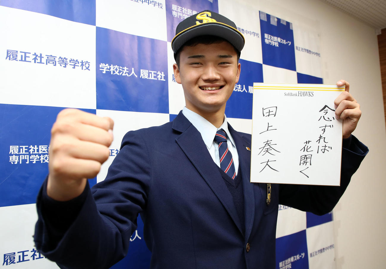 ソフトバンクから指名あいさつを受けた田上は色紙に座右の銘を書いて笑顔を見せる（撮影・加藤哉）