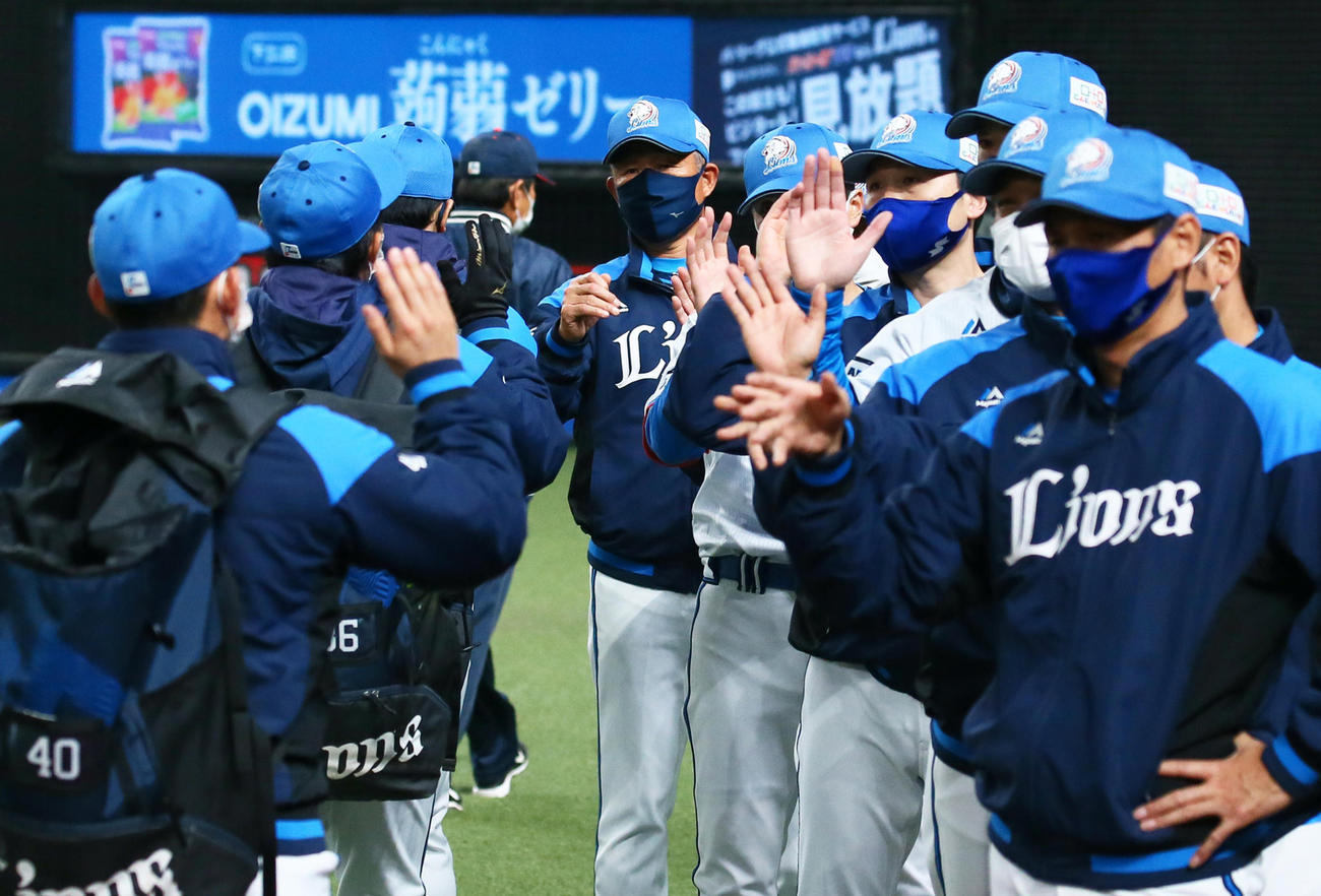 西武対日本ハム　勝利しタッチでナインを迎える西武辻監督（中央）（撮影・足立雅史）