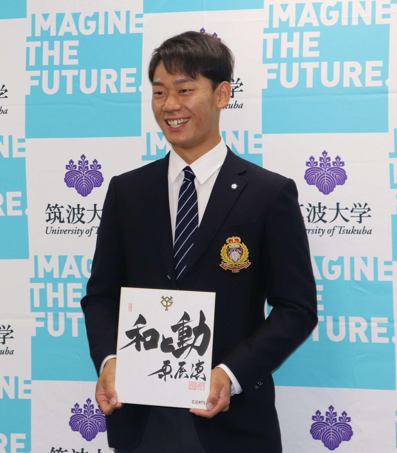 巨人原監督のサイン色紙を手に笑顔を見せる筑波大・奈良木（撮影・小早川宗一郎）