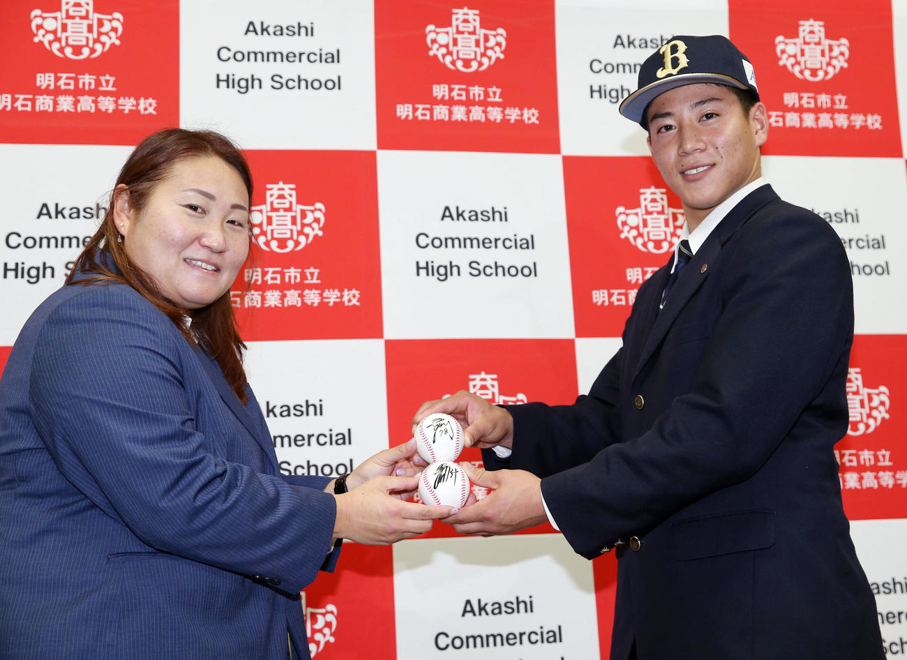 オリックスから指名あいさつを受け、乾スカウト（左）から中嶋監督代行と吉田正のサインボールを贈られ笑顔を見せるドラフト3位の明石商・来田（撮影・前田充）