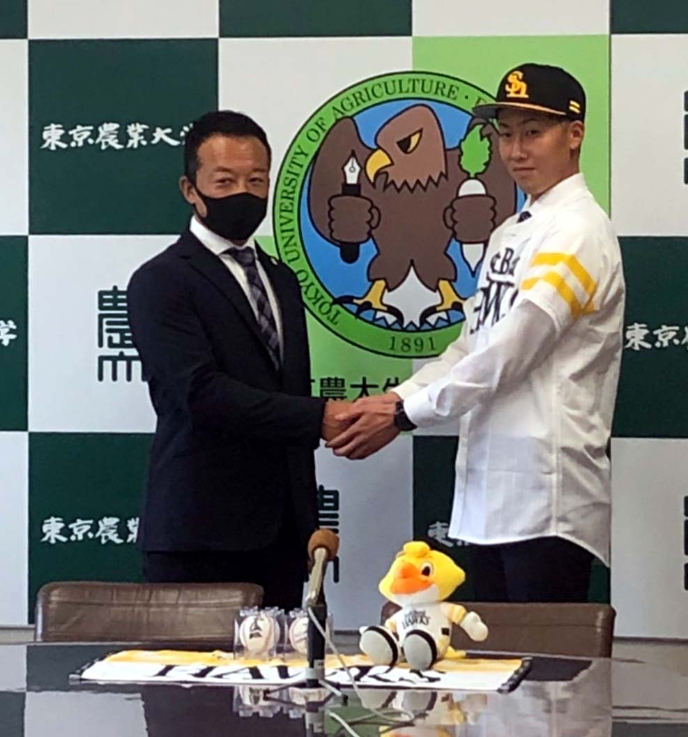 ソフトバンクの作山スカウトと握手する東農大北海道の中村（右）（東農大北海道提供）