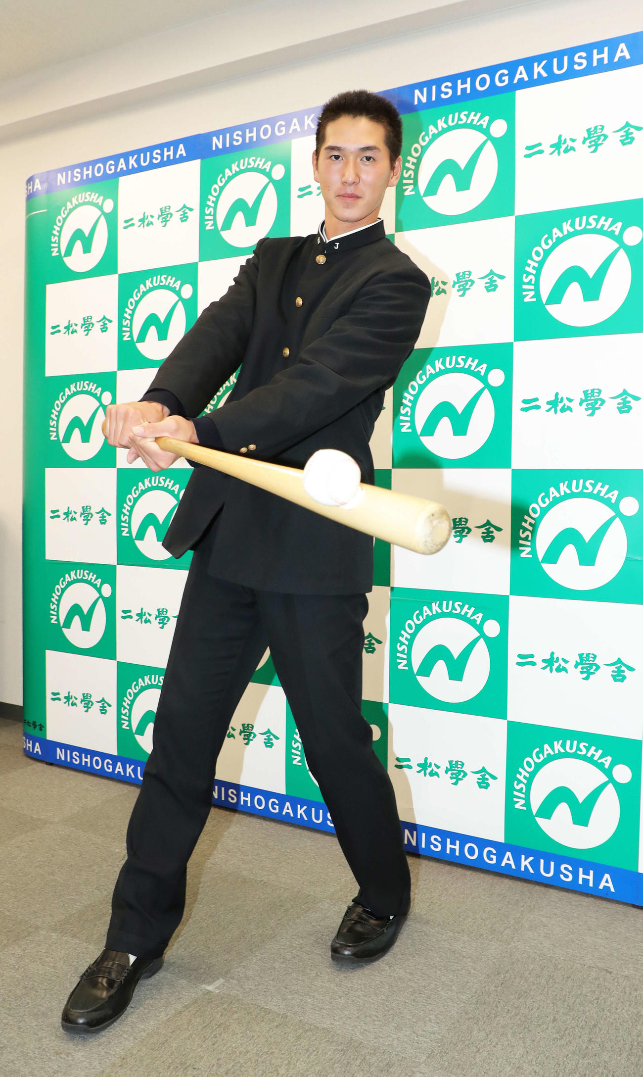 スイングのポーズで写真に納まる巨人5位指名の二松学舎大付・秋広（撮影・河田真司）