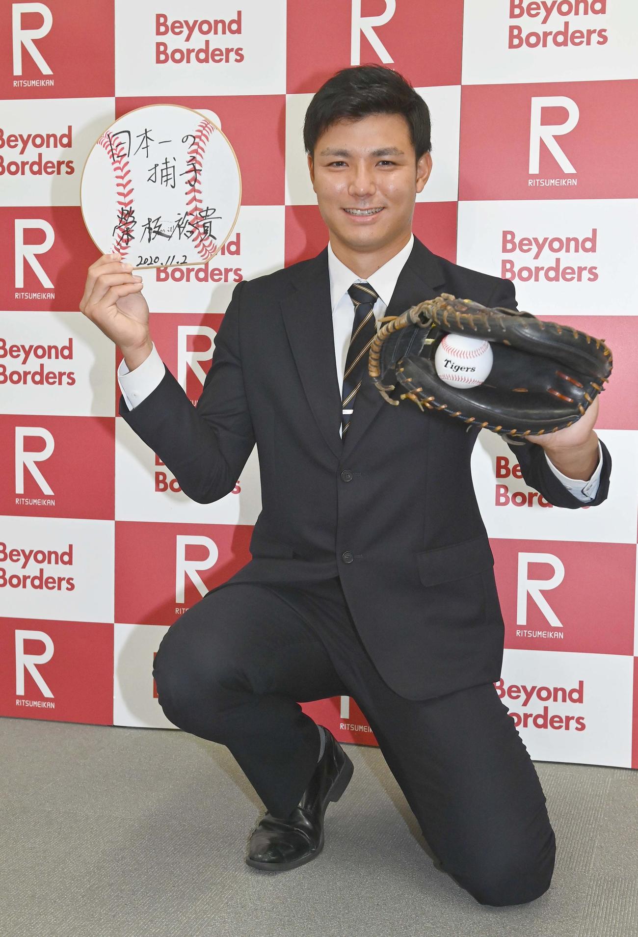 阪神ドラフト4位で指名あいさつを受けた立命大・栄枝は笑顔でポーズを決める（撮影・上田博志）