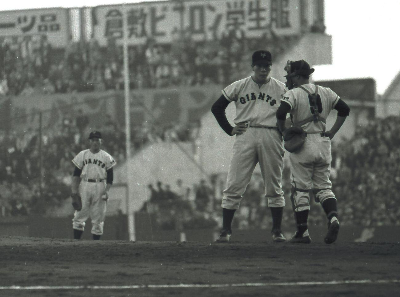 57年10月、阪神戦に登板したジャイアント馬場さん（中央）は捕手藤尾と打ち合わせ。左後方は一塁手の川上哲治さん
