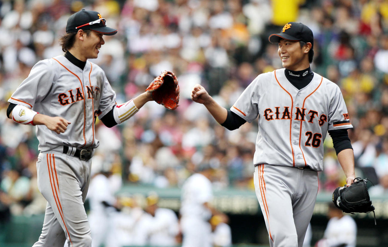 11年9月、阪神戦で好守して巨人内海（右）とタッチを交わす坂本