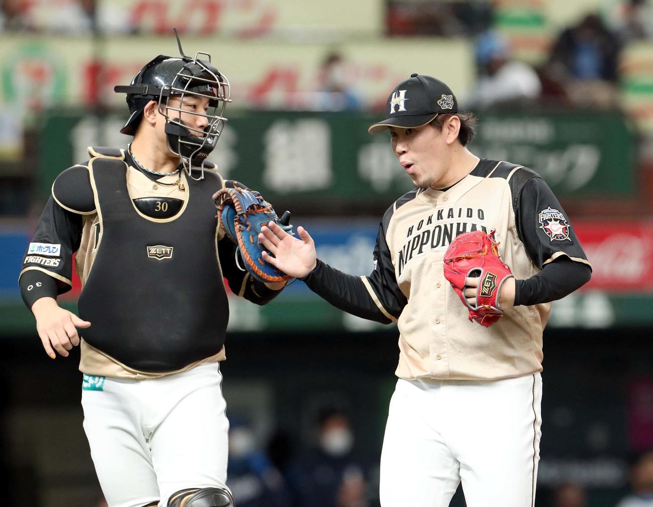 西武対日本ハム　タッチを交わしながらベンチに戻る日本ハム宇佐見（左）と西村（撮影・佐藤翔太）