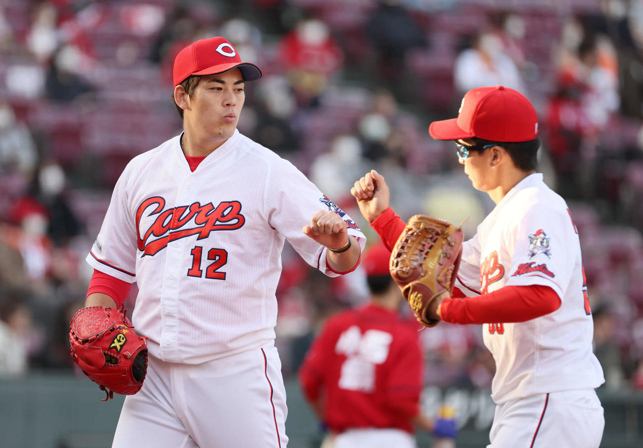 広島対巨人　7回表終了でベンチに戻る九里亜蓮（左）と大盛穂はグータッチ（撮影・加藤孝規）