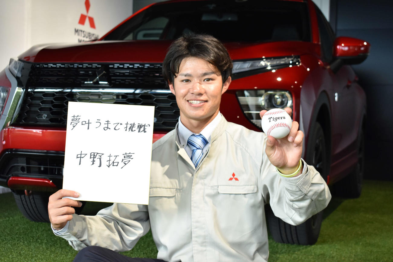 阪神にドラフト6位で指名された三菱自動車岡崎・中野は、座右の銘を書いた色紙と、タイガースボールを持って笑顔を見せる（撮影・只松憲）