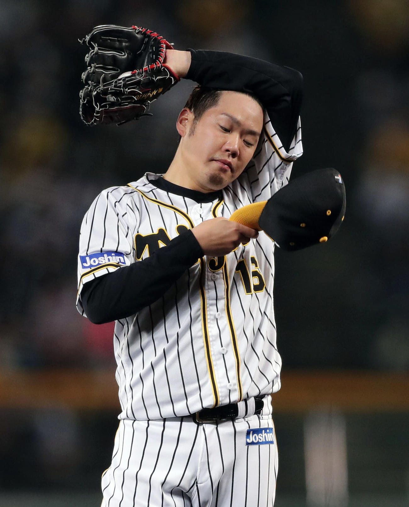 阪神対ヤクルト　1回表ヤクルト1死一、三塁、打者エスコバーのとき、一塁へのけん制悪送球で追加点を許し、汗をぬぐう西勇（撮影・前田充）