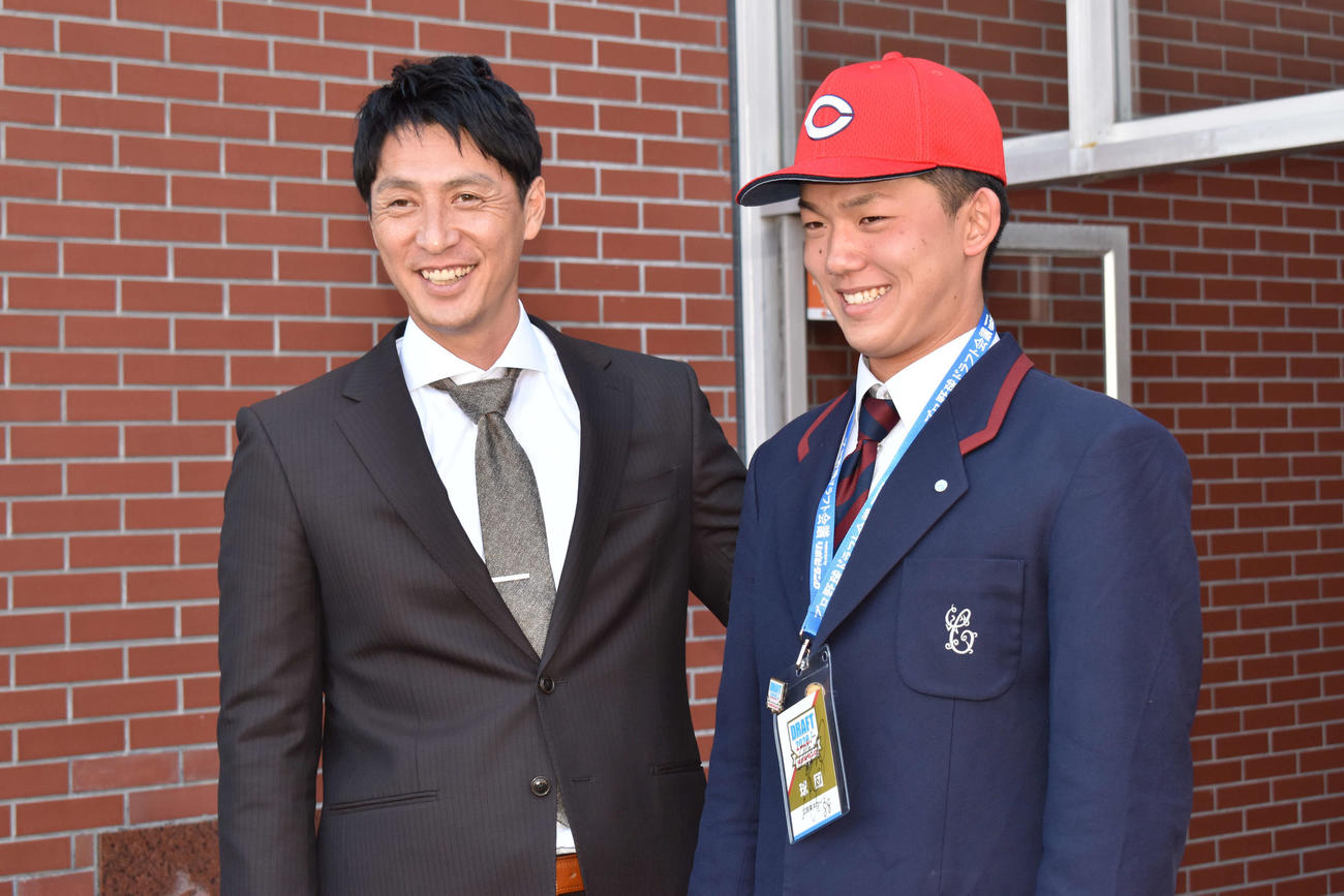 笑顔で写真撮影に応じる広島ドラフト4位の智弁和歌山・小林（右）と鞘師スカウト（撮影・古財稜明）