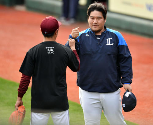 楽天対西武　試合前練習で楽天渡辺直（手前）とグータッチする西武中村（撮影・滝沢徹郎）