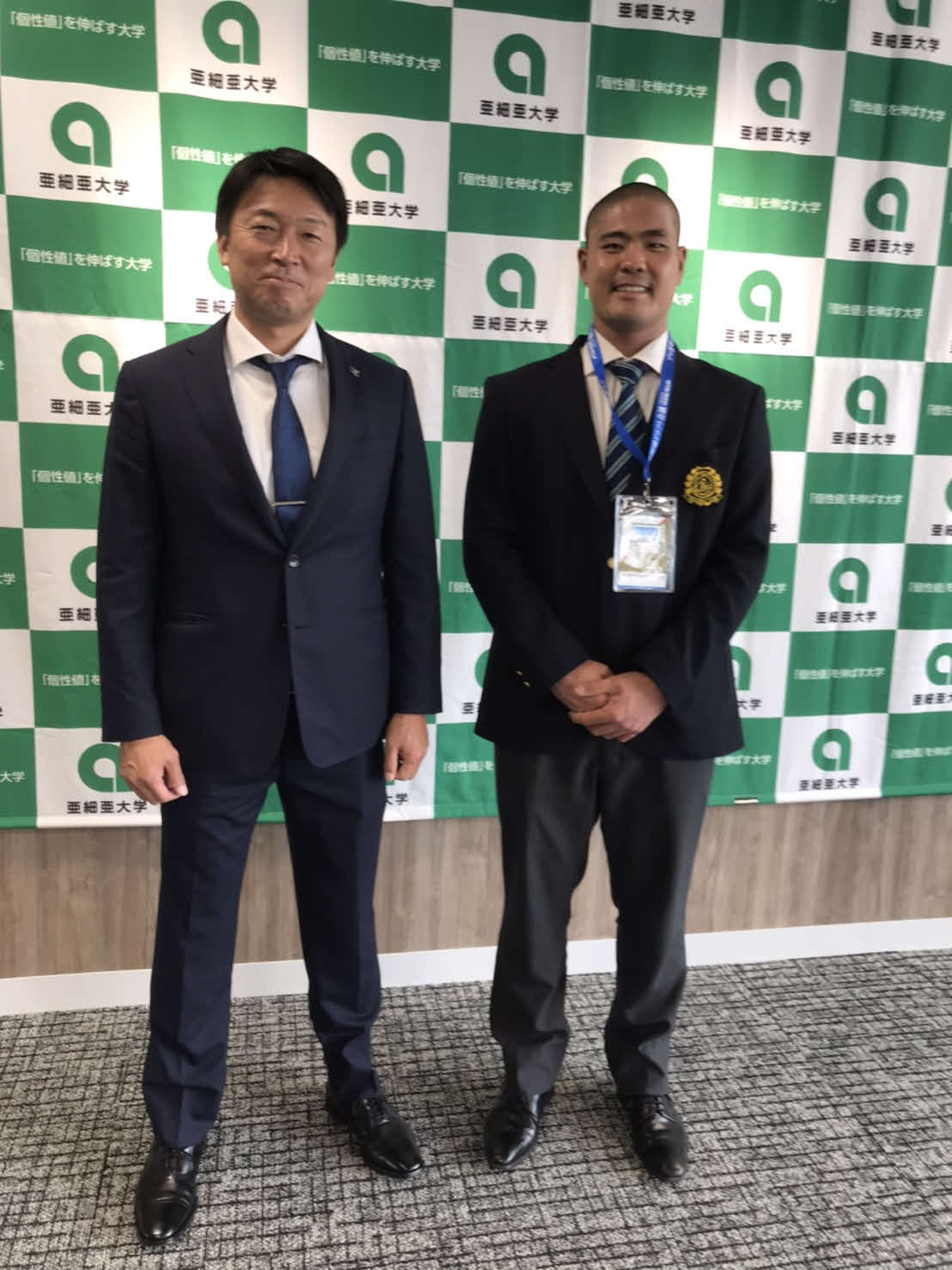 指名あいさつを終え、担当の沖原スカウト（左）と記念撮影をする楽天ドラフト4位指名の亜大・内間（右）（球団提供）
