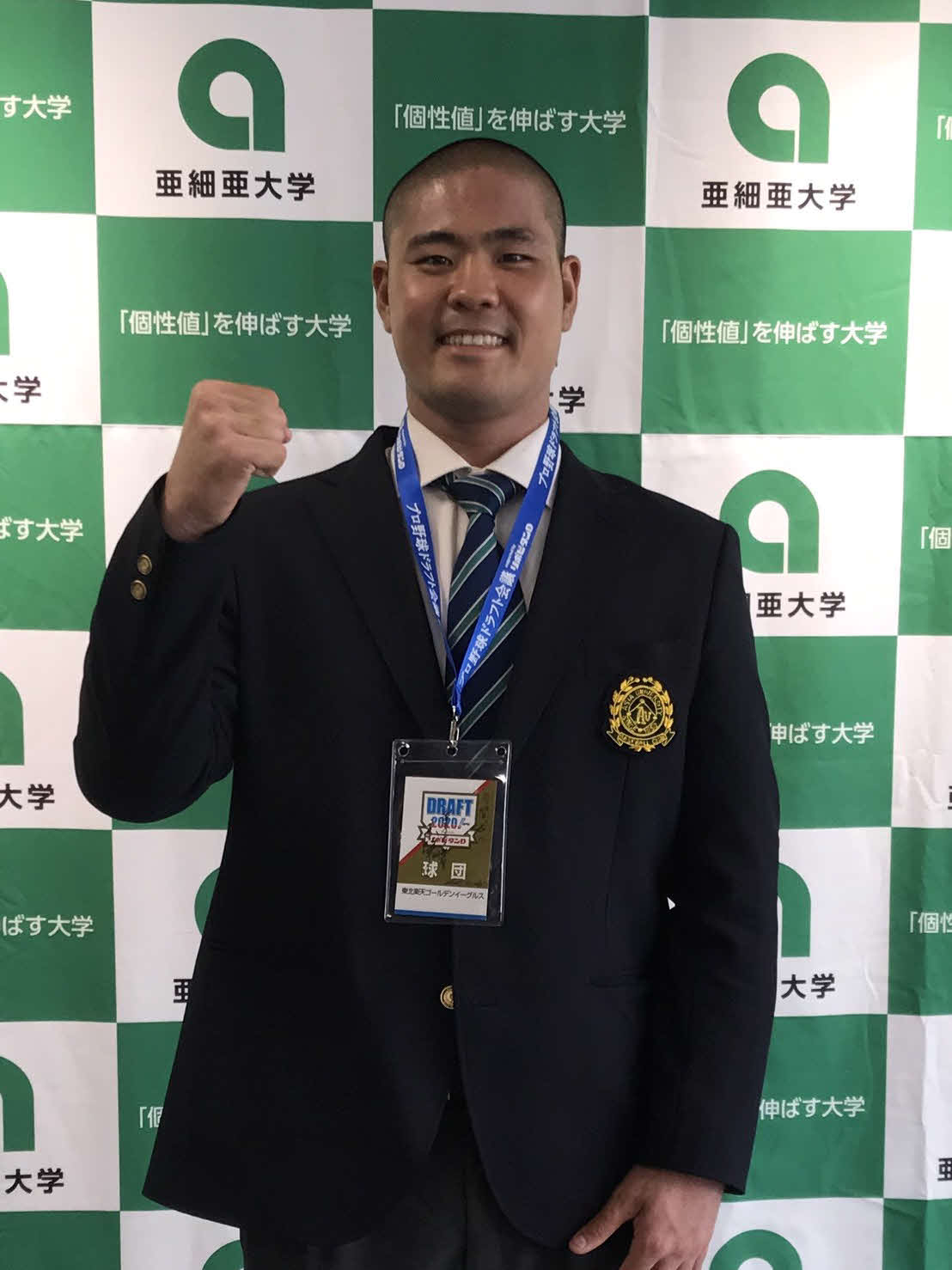 指名あいさつを終え、笑顔でガッツポーズを見せる楽天ドラフト4位指名の亜大・内間（球団提供）