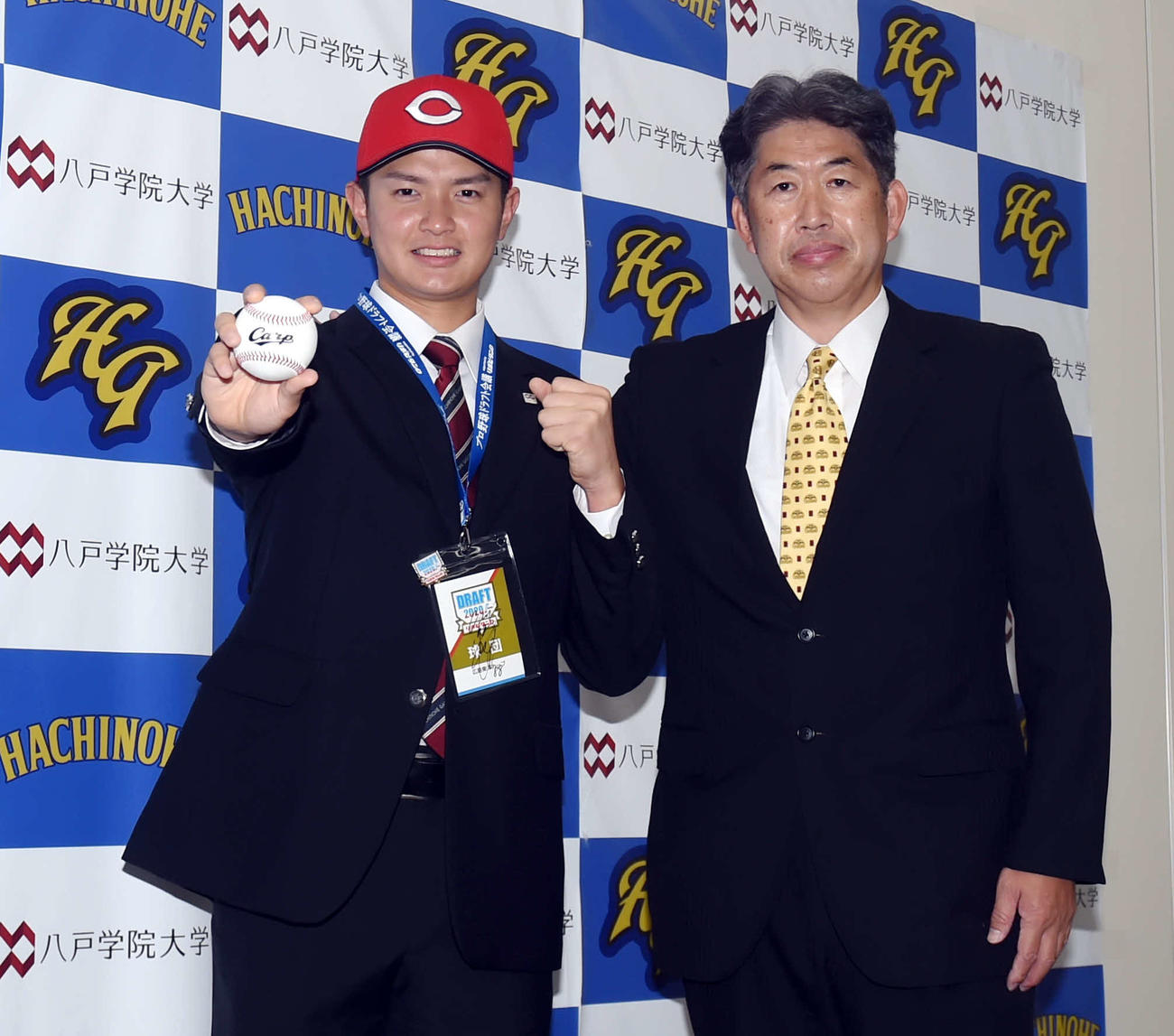 笑顔でツーショットに納まる八戸学院大・大道（左）と広島近藤スカウト（撮影・相沢孔志）