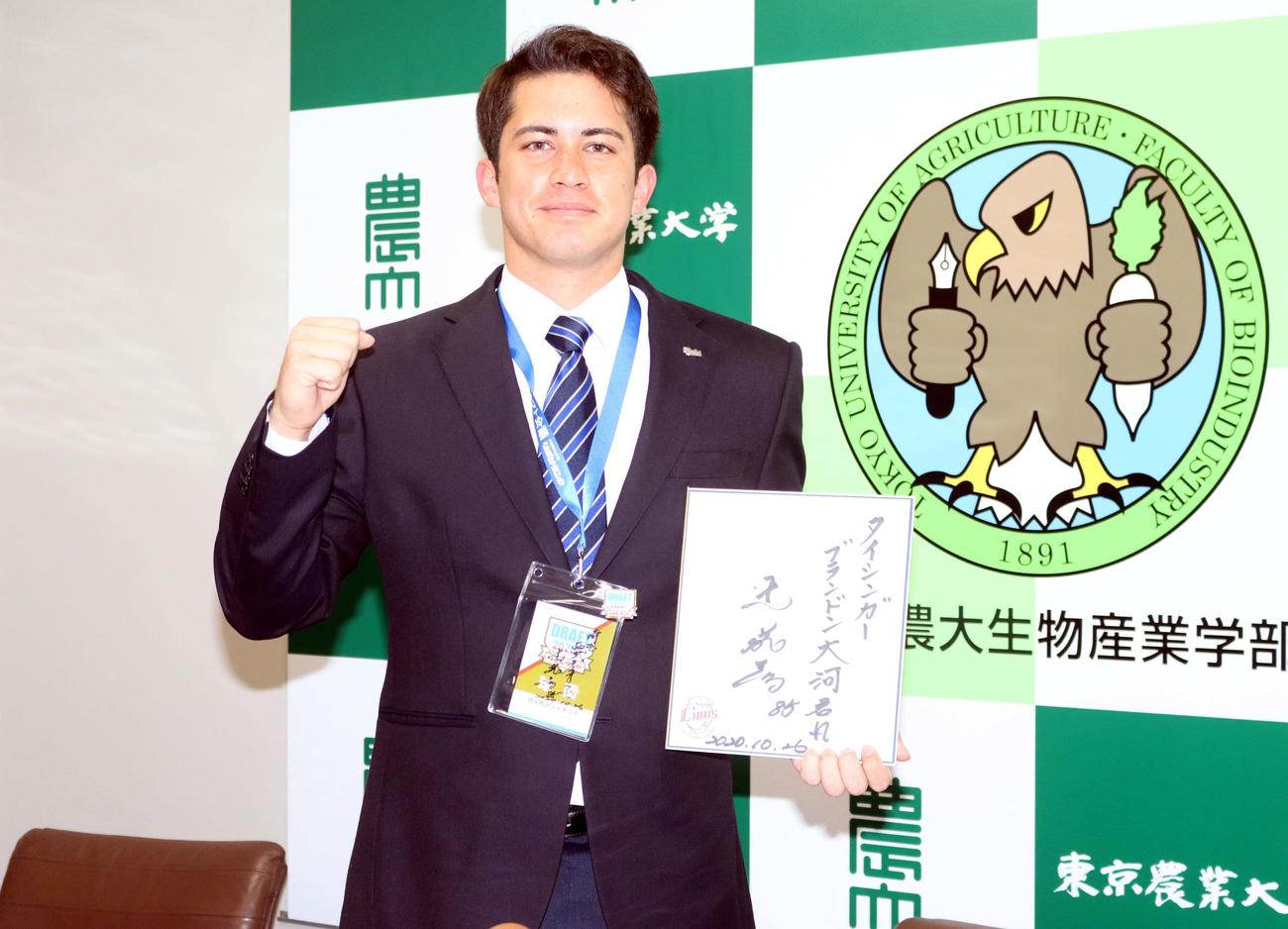 西武・辻監督直筆の書を手に、ポーズを取る東農大北海道のブランドン大河（撮影・永野高輔）