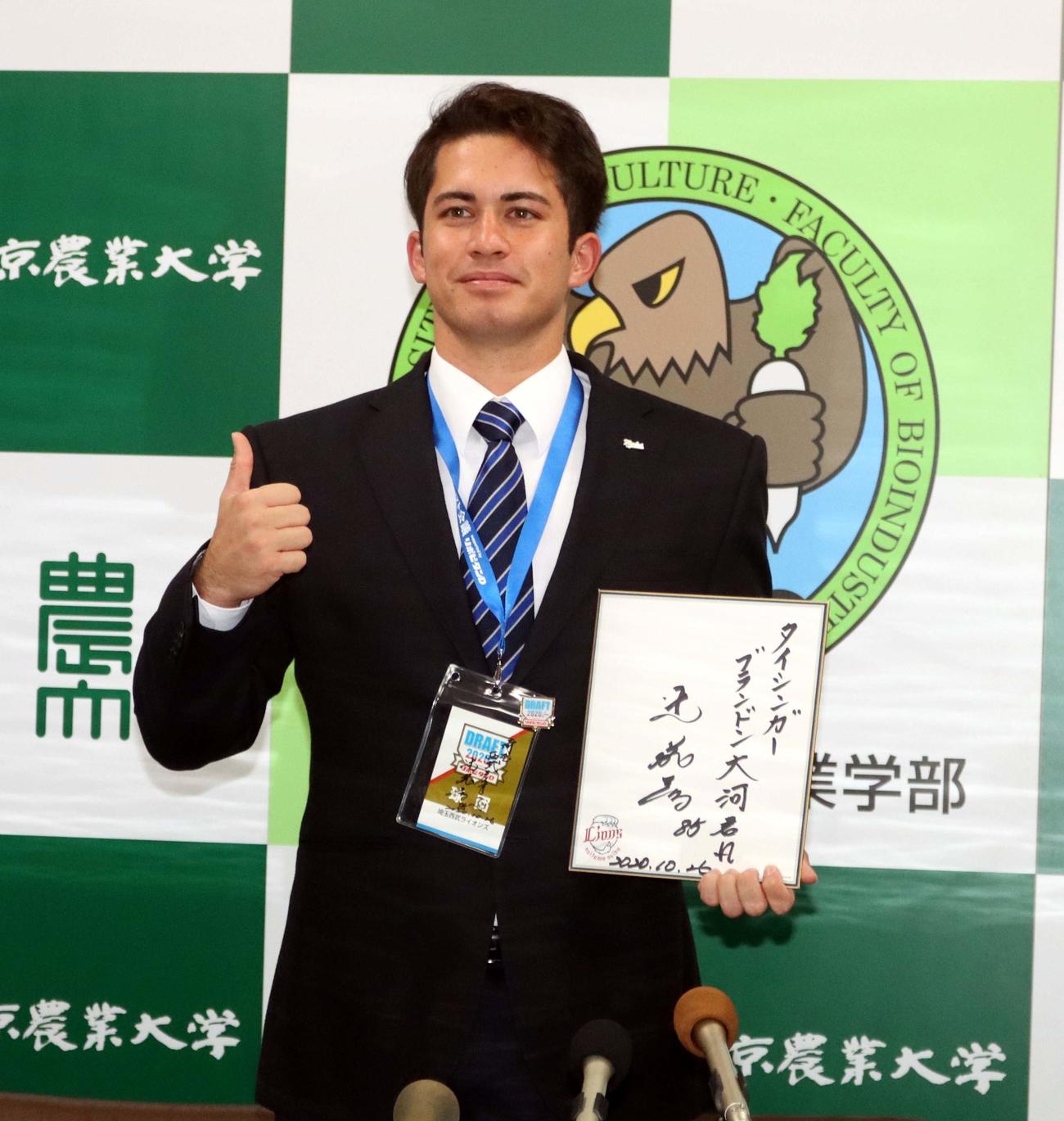 西武・辻監督直筆の書を手に、ポーズを取る東農大北海道オホーツク・ブランドン大河（撮影・永野高輔）