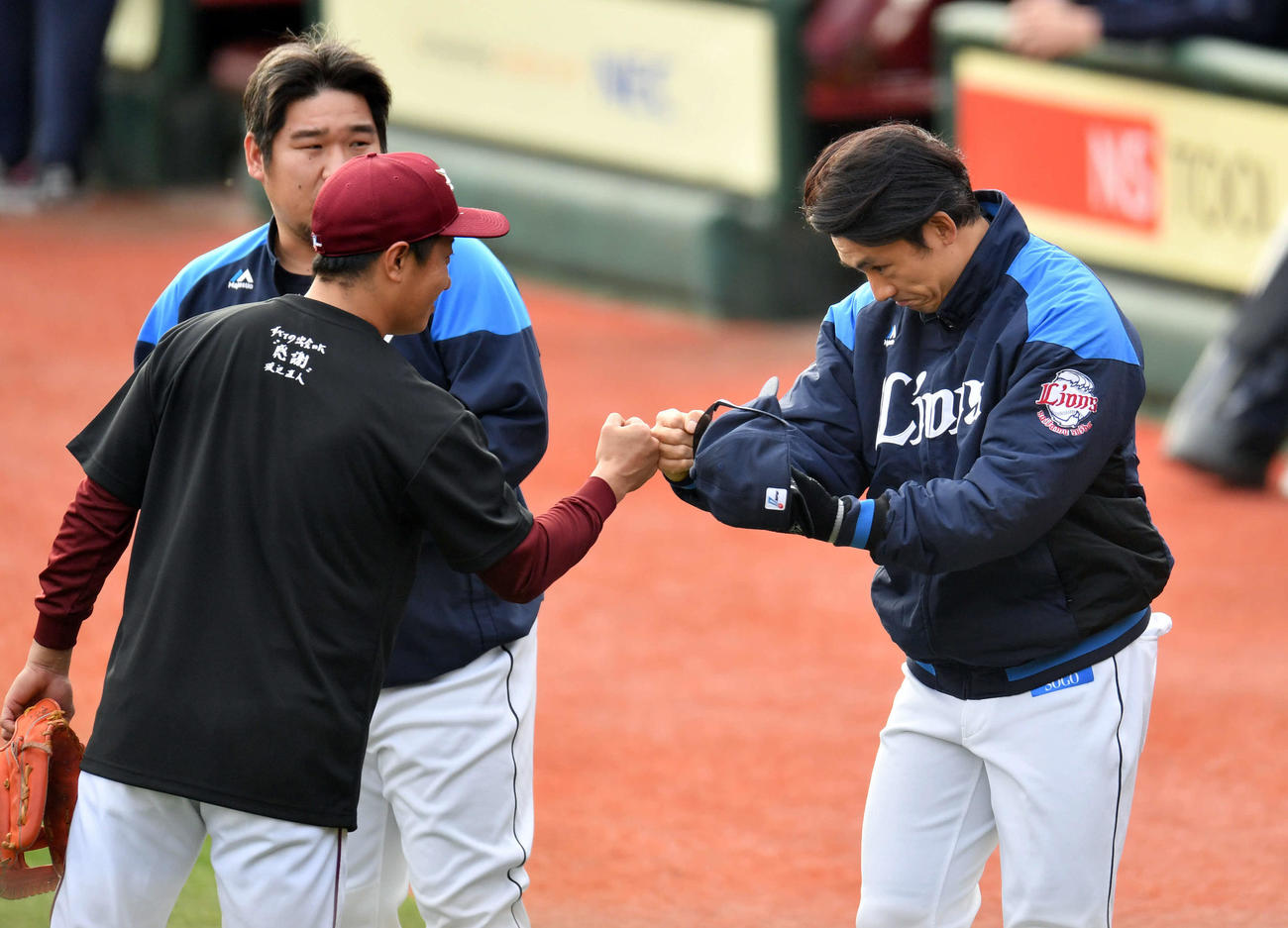 楽天対西武　試合前練習で楽天渡辺直（左手前）とグータッチする西武栗山（撮影・滝沢徹郎）