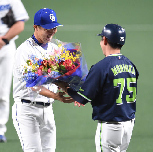 中日対ヤクルト　森岡良介内野守備走塁コーチ（右）から花束を受け取る吉見一起（撮影・森本幸一）