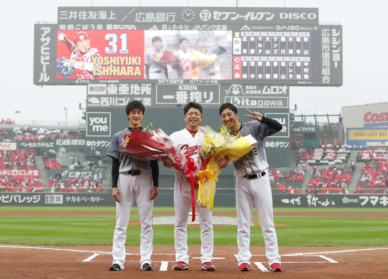 プロ野球広島対阪神　　石原慶幸に花束を渡した能見篤史（左）と藤川球児（右）
