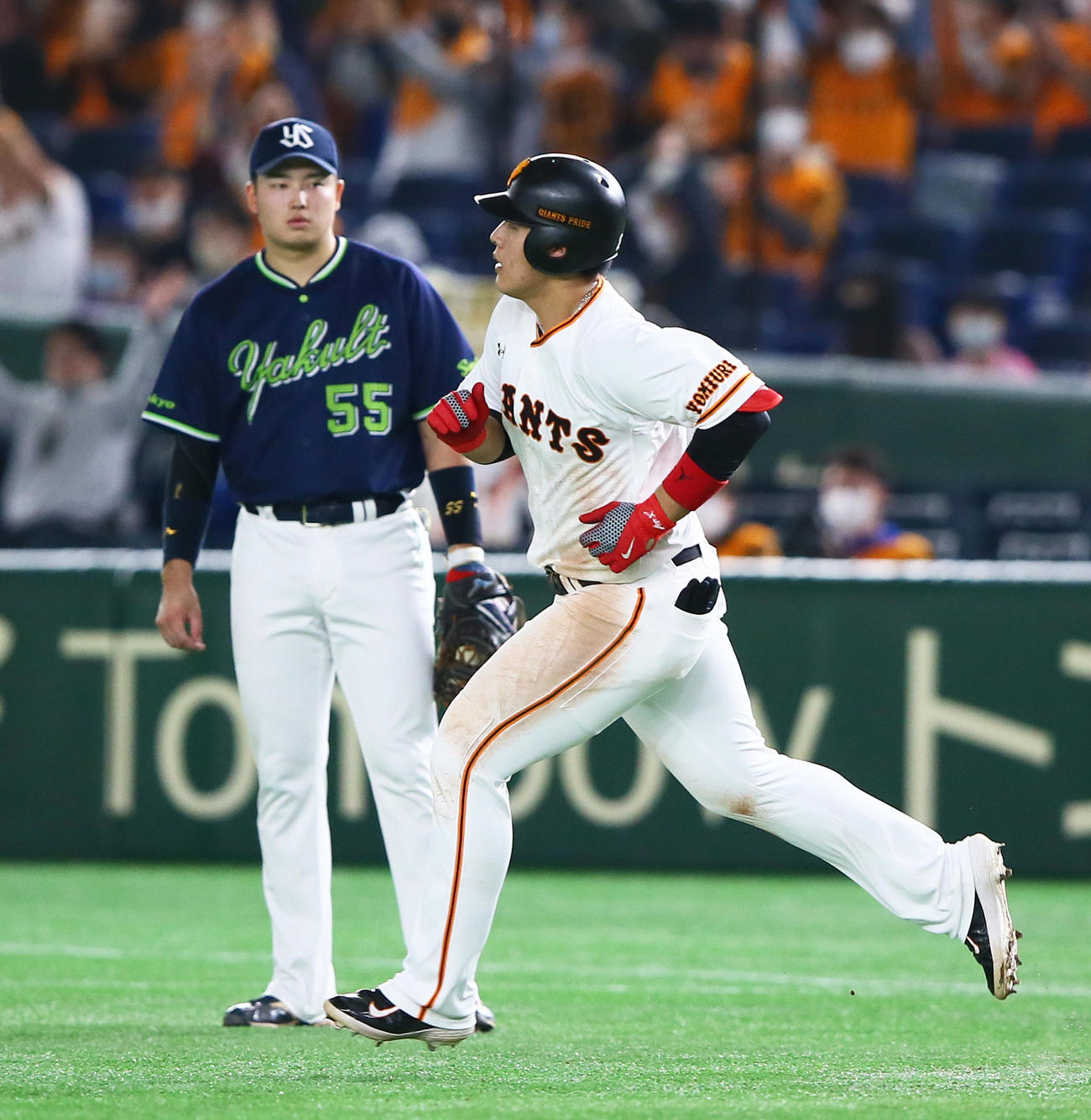 巨人対ヤクルト　5回裏巨人無死、右越え本塁打を放った岡本（右）。左はヤクルト一塁手村上（撮影・足立雅史）